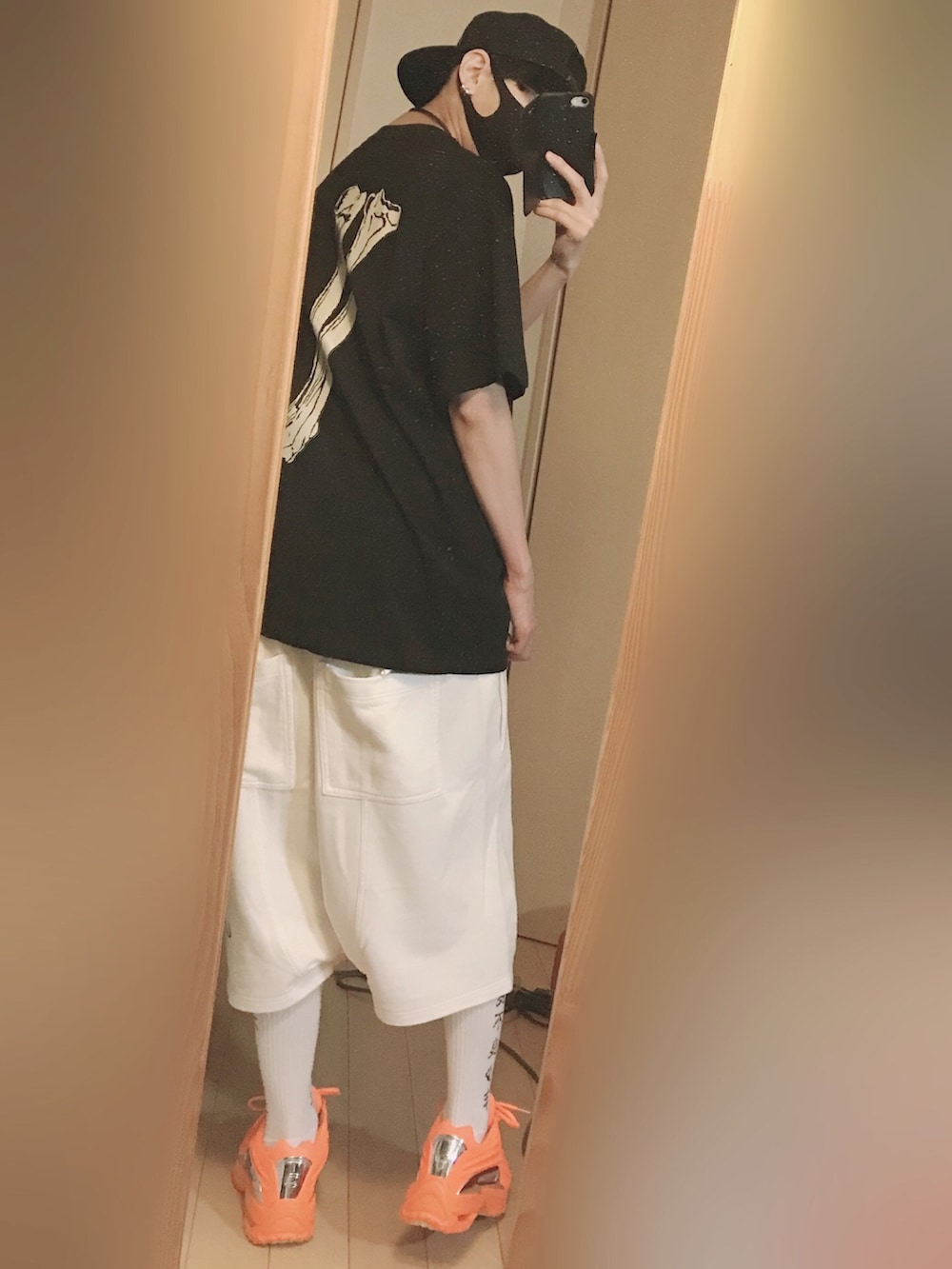 オレンジ系のスニーカー、ブラック系のTシャツ/カットソー、ホワイト系のデニムパンツを着用したメンズの夏コーディネートの5枚目の写真