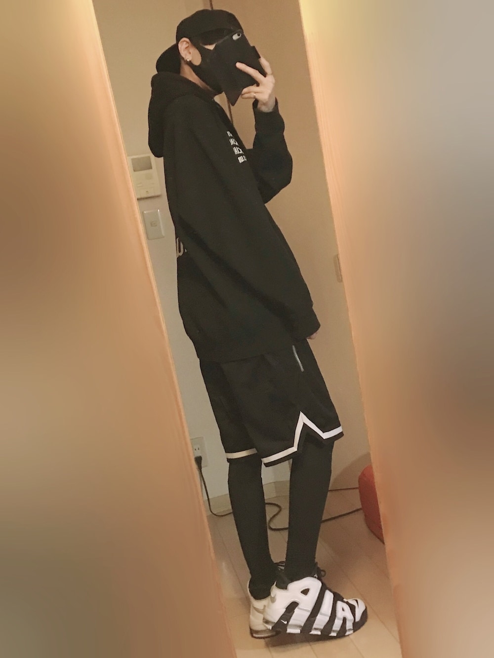 ブラック系のパーカー、ブラック系のパンツ、ブラック系のスニーカーを着用したメンズの秋コーディネートの4枚目の写真