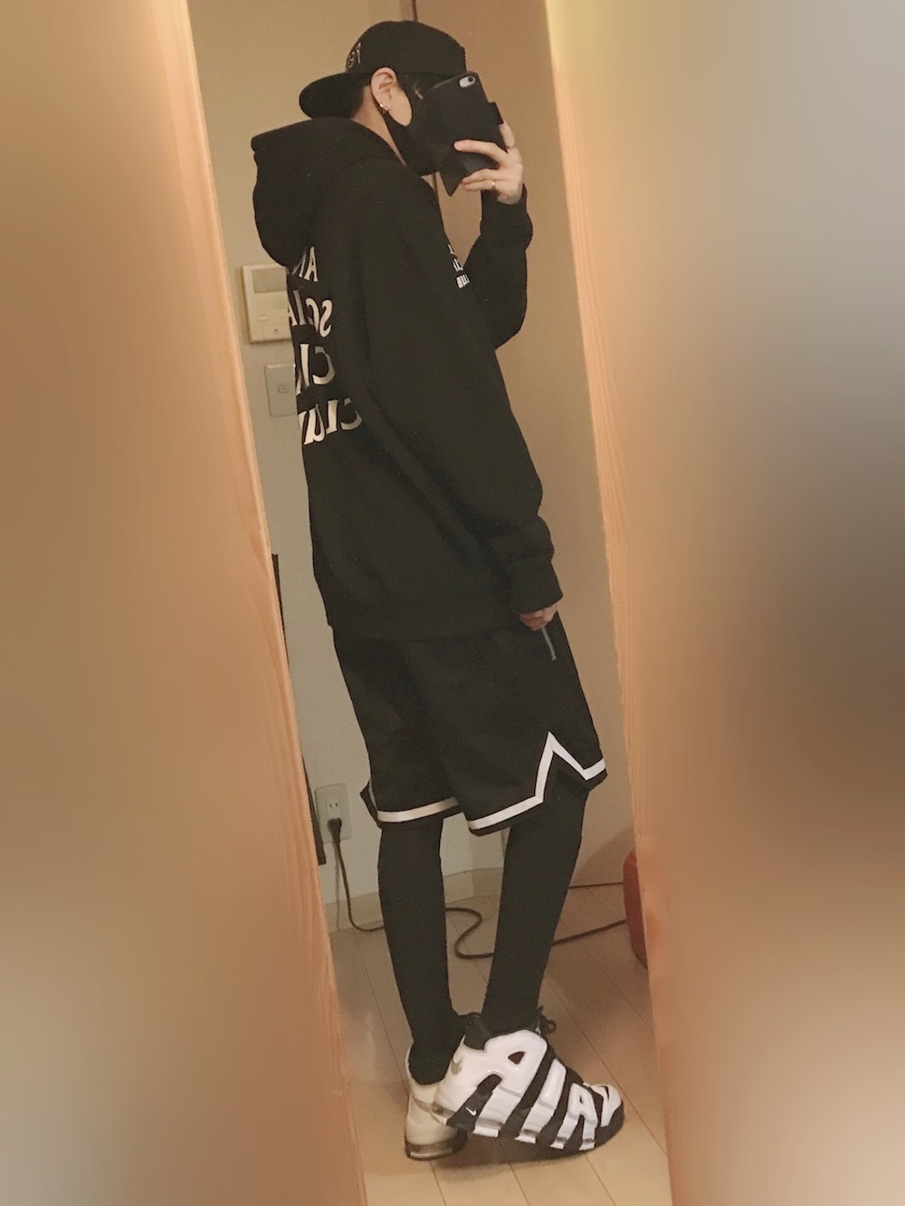 ブラック系のパーカー、ブラック系のパンツ、ブラック系のスニーカーを着用したメンズの秋コーディネートの2枚目の写真