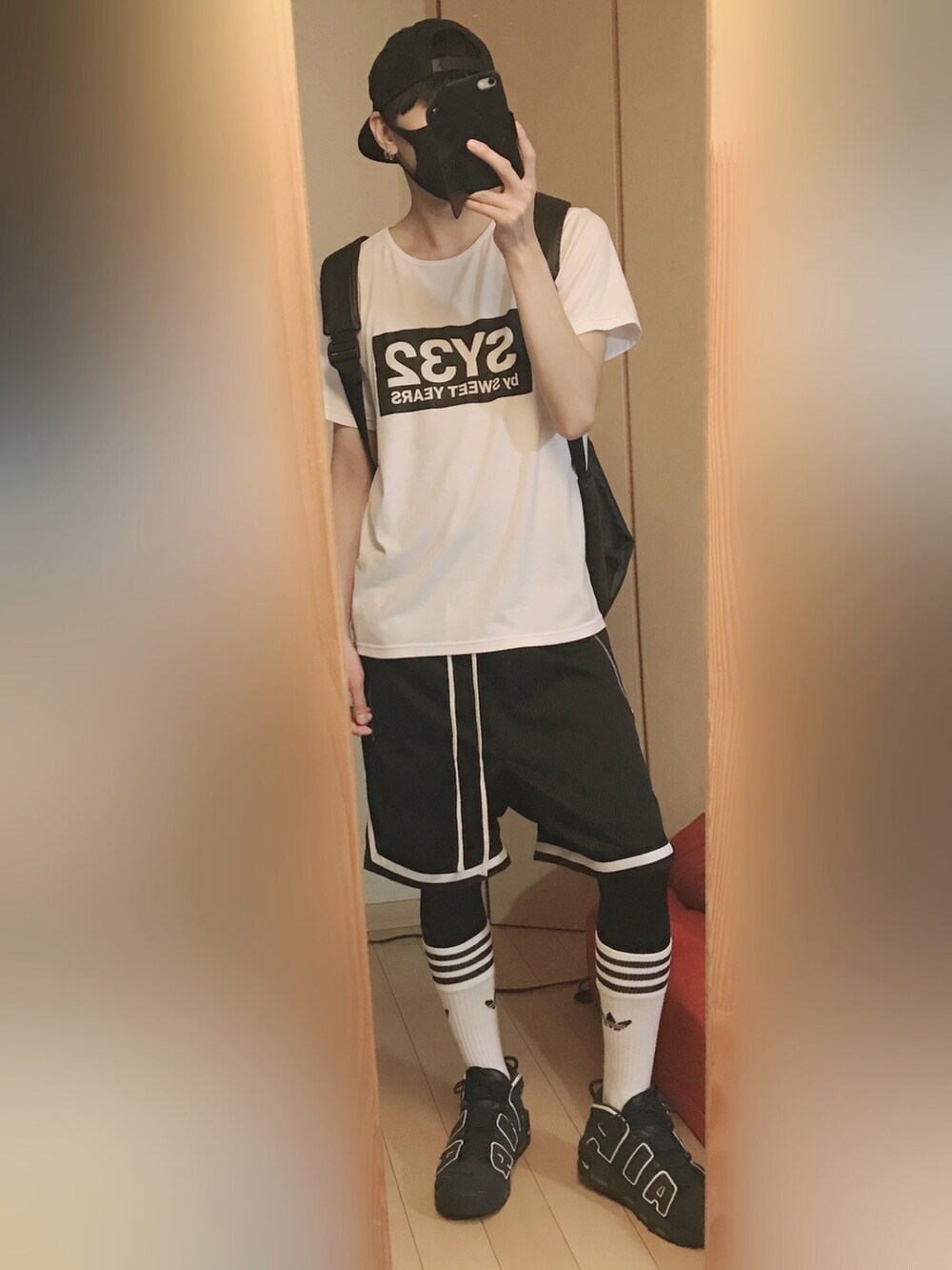 ホワイト系のTシャツ/カットソー、ブラック系のパンツ、ブルー系のスニーカーを着用したメンズの夏コーディネートの2枚目の写真