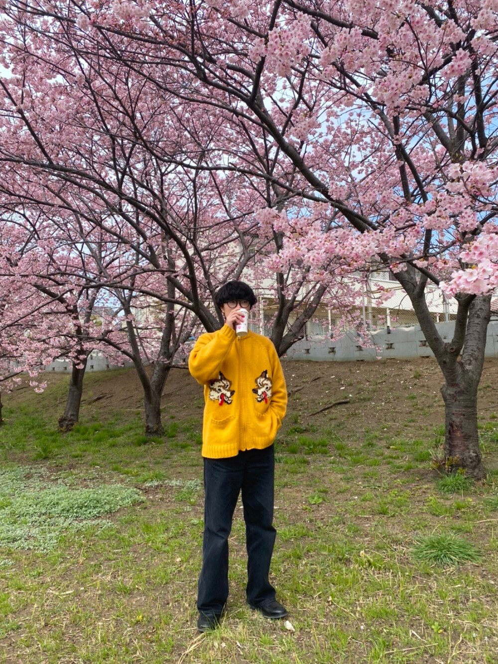 ブラック系のデニムパンツ、オレンジ系のTシャツ/カットソー、ブラック系のローファーを着用したメンズの春コーディネートの2枚目の写真