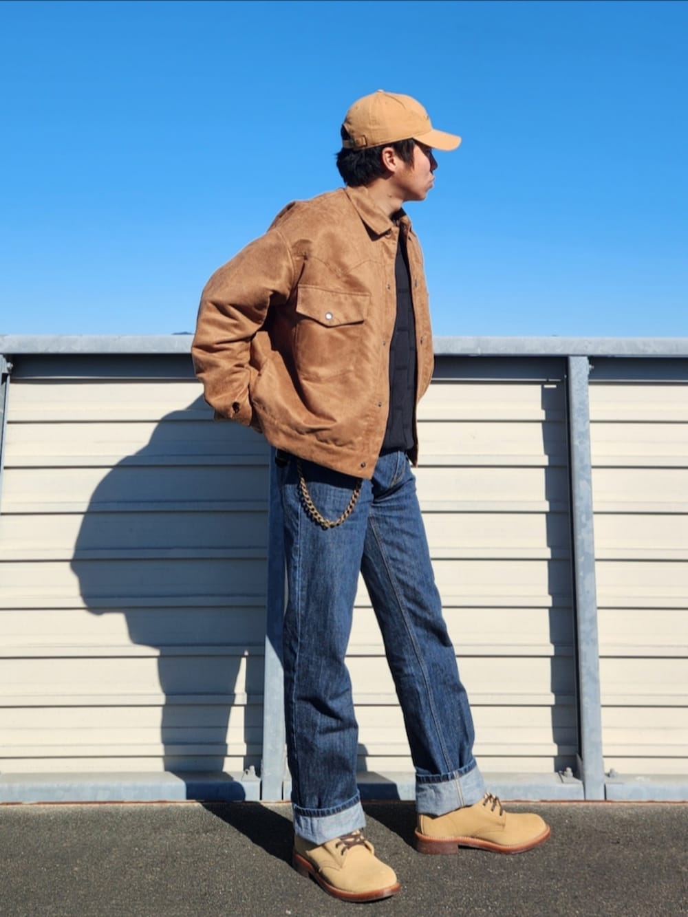 ブラック系のニット/セーター、ブラウン系のブルゾン、ブルー系のデニムパンツを着用したメンズの冬コーディネートの3枚目の写真