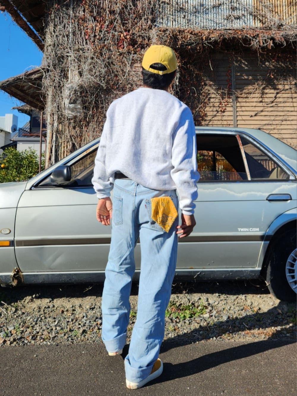 ホワイト系のスウェット、ブルー系のデニムパンツ、イエロー系のスニーカーを着用したメンズの冬コーディネートの2枚目の写真