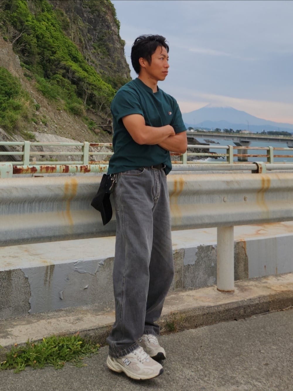 グリーン系のTシャツ/カットソー、ホワイト系のスニーカー、グレー系のデニムパンツを着用したメンズの春コーディネートの3枚目の写真