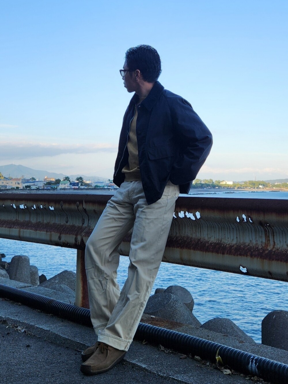 ブラック系のジャケット/アウター、イエロー系のトップス、ホワイト系のデニムパンツを着用したメンズの秋コーディネートの2枚目の写真