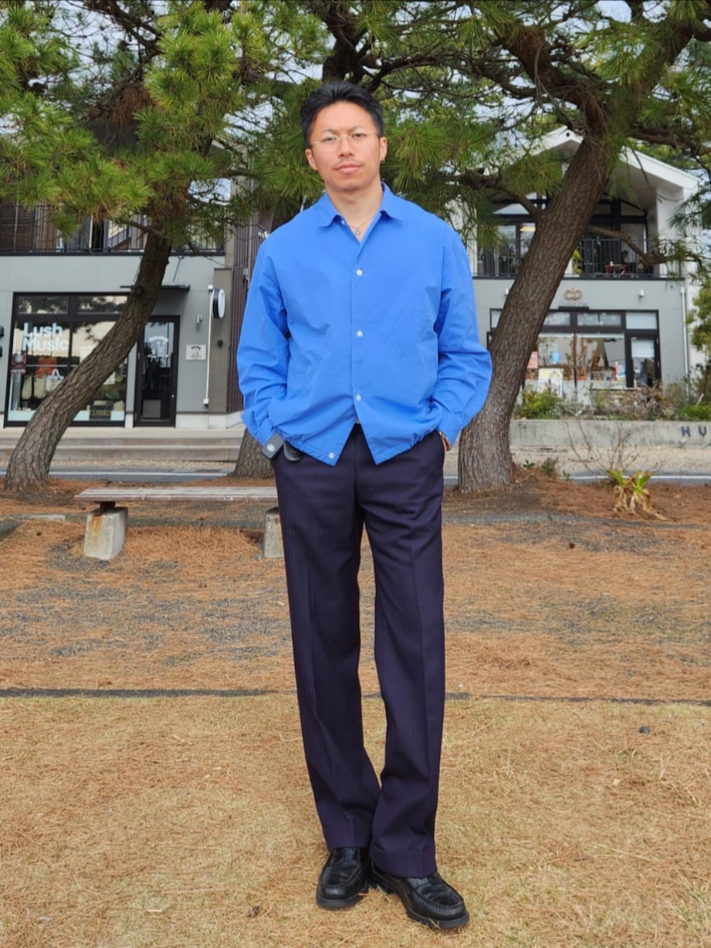 ブルー系のシャツ/ブラウス、ブルー系のスラックス、ブラック系のローファーを着用したメンズの春コーディネートの2枚目の写真