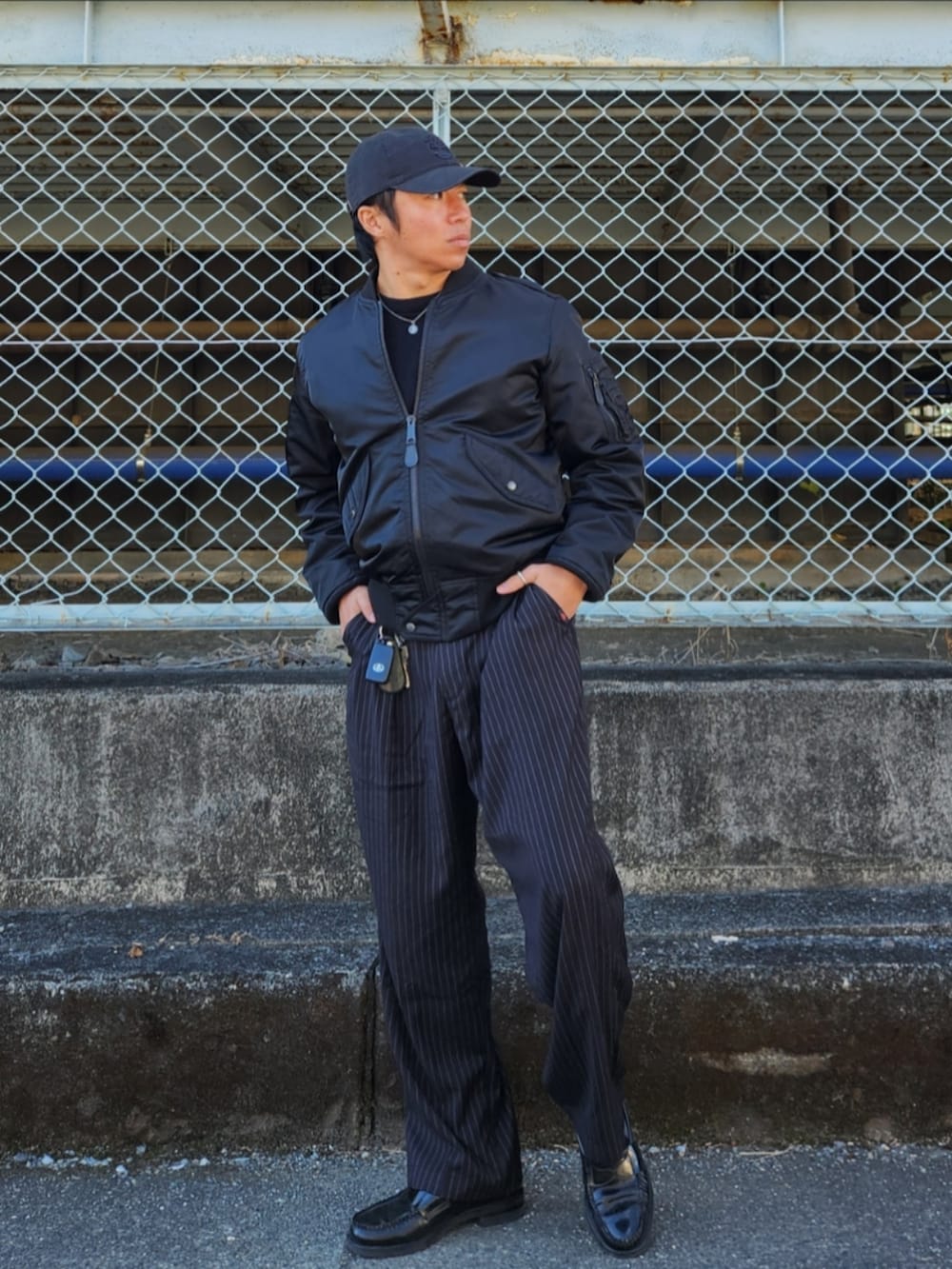 ブラック系のMA-1、ブラック系のスラックス、ブラック系のローファーを着用したメンズの冬コーディネートの3枚目の写真