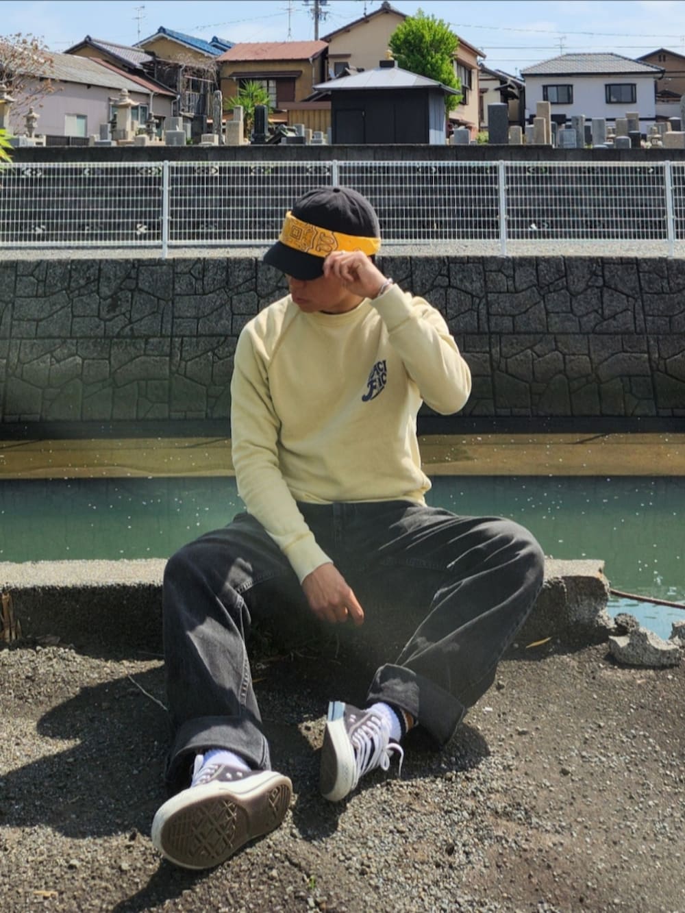 ブラック系のスニーカー、ブラック系のデニムパンツ、イエロー系のスウェットを着用したメンズの春コーディネートの2枚目の写真