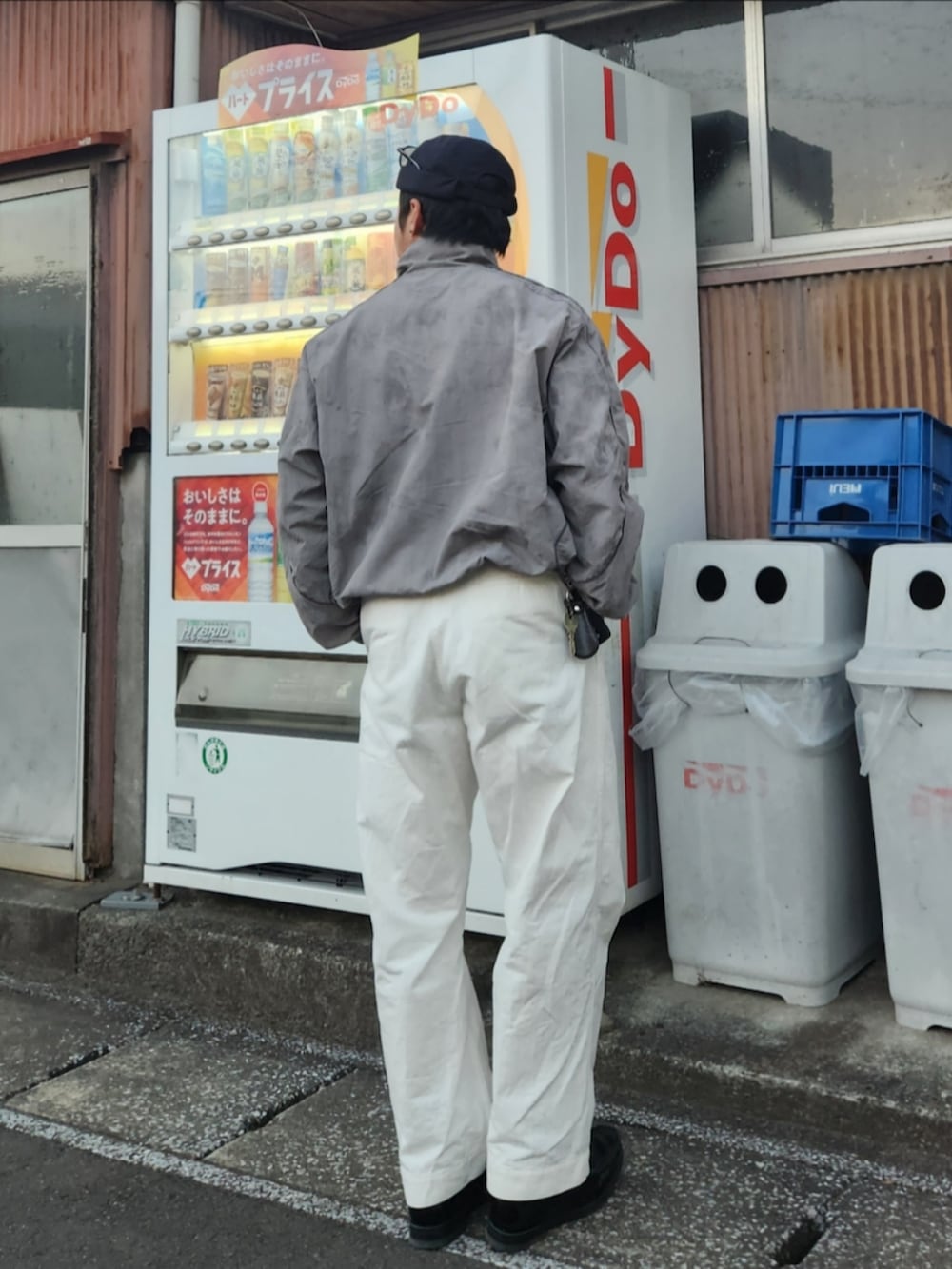 シルバー系のナイロンジャケット、ホワイト系のパンツ、ブラック系のローファーを着用したメンズの冬コーディネートの2枚目の写真