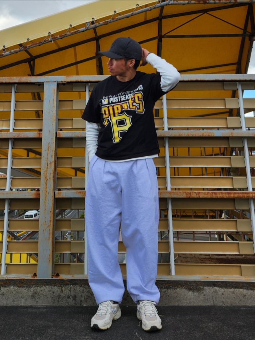 グレー系のスウェットパンツ、ホワイト系のスニーカー、ブラック系のスタジャンを着用したメンズの冬コーディネートの2枚目の写真