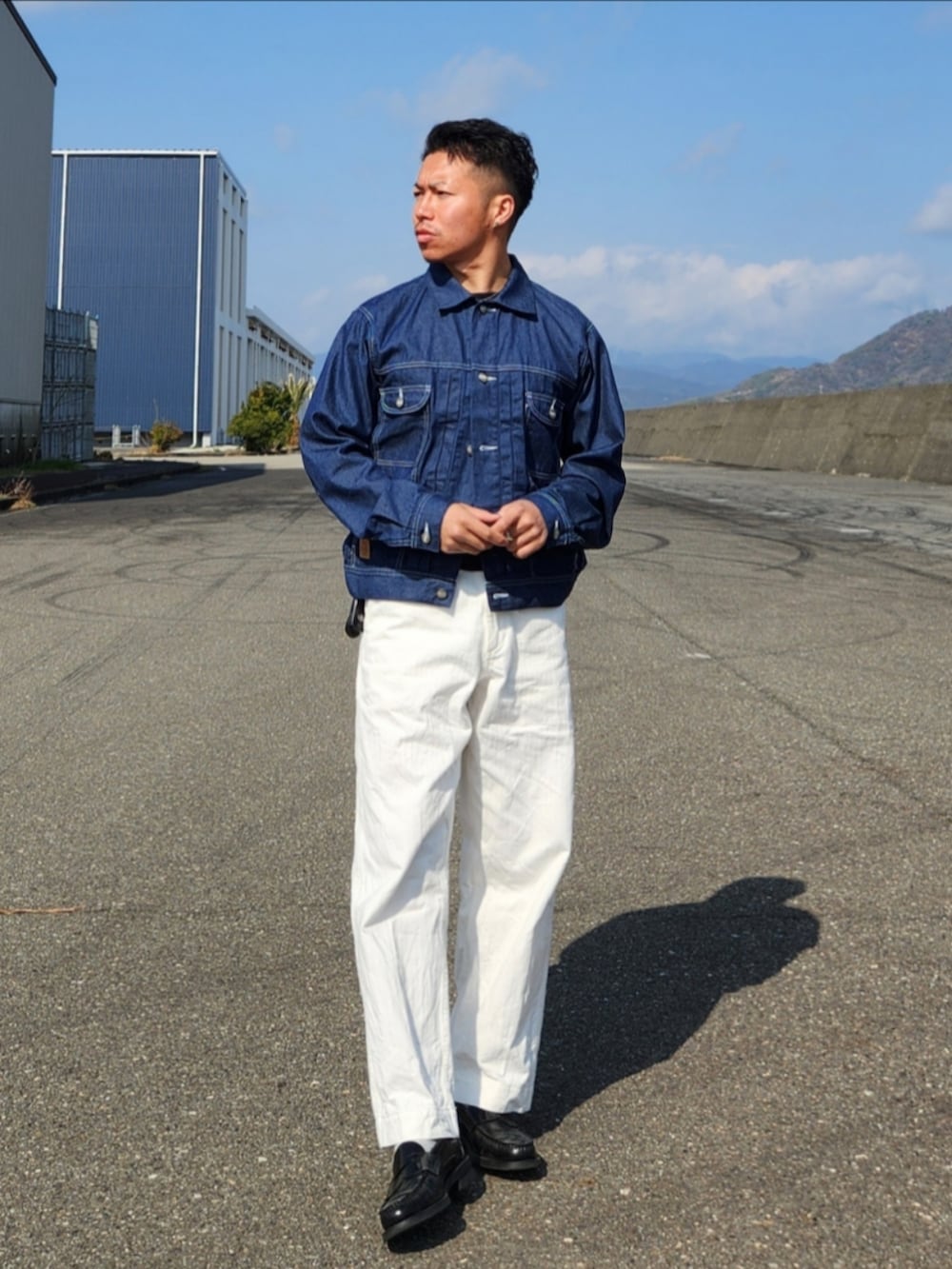 ホワイト系のパンツ、ブラック系のローファー、ブルー系のデニムジャケットを着用したメンズの冬コーディネートの2枚目の写真