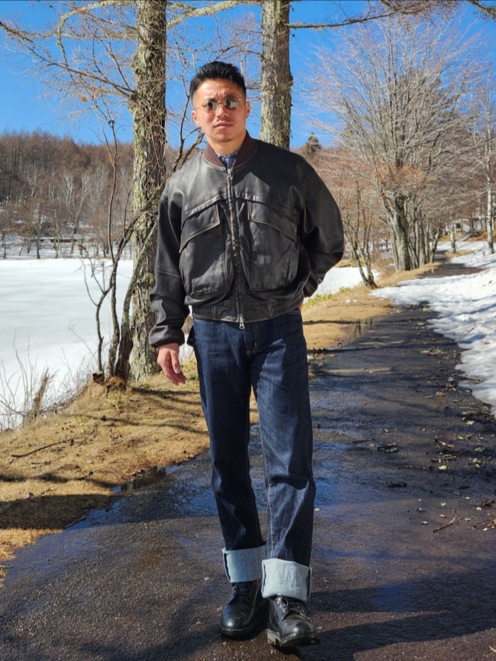 ブラウン系のブルゾン、ブルー系のデニムパンツ、ブラック系のブーツを着用したメンズの冬コーディネートの2枚目の写真