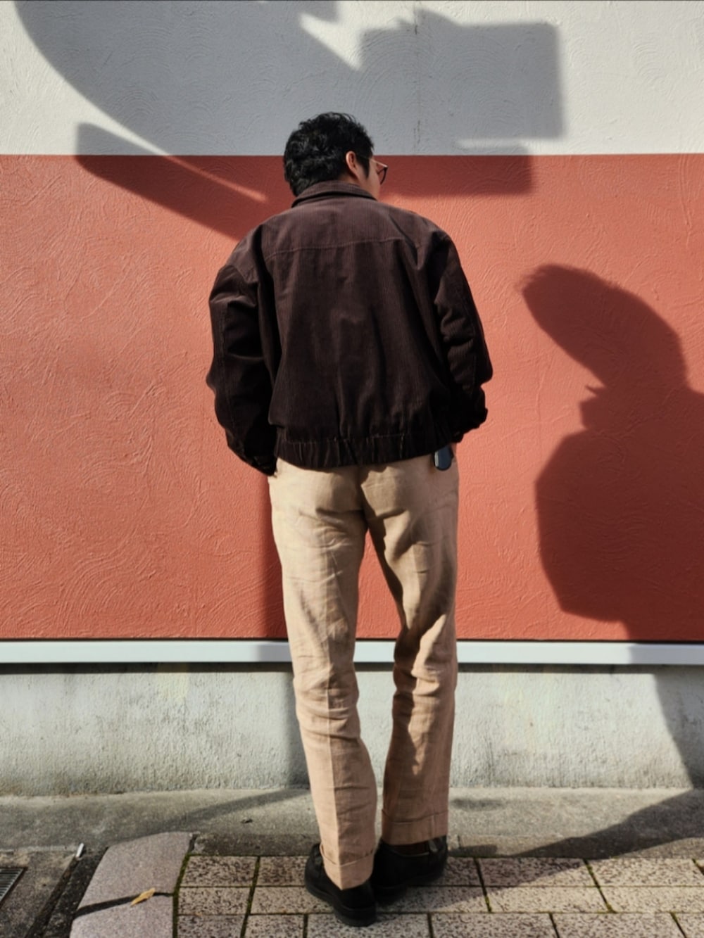 ブラック系のジャケット/アウター、ブラウン系のその他トップス、ベージュ系のスラックスを着用したメンズの冬コーディネートの3枚目の写真