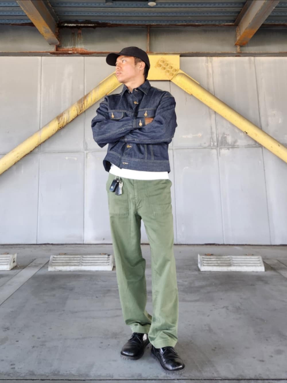 ブルー系のデニムジャケット、グリーン系のカーゴパンツ、ブラック系のブーツを着用したメンズの秋コーディネートの2枚目の写真