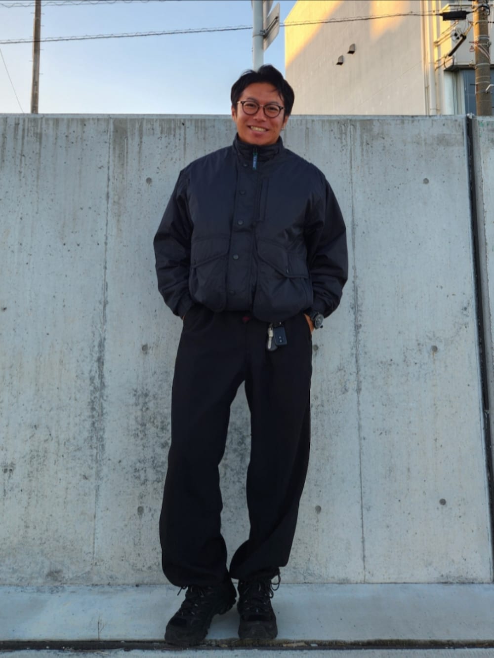 ブラック系のダウンジャケット/コート、ブラック系のスラックス、ブラック系のスニーカーを着用したメンズの冬コーディネートの2枚目の写真