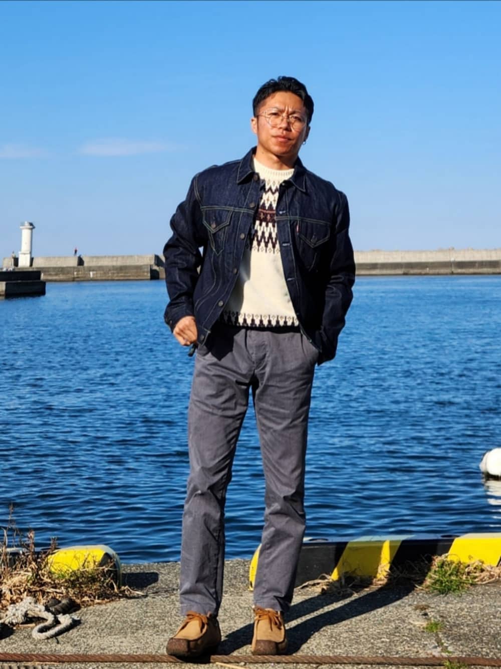 ホワイト系のニット/セーター、ブルー系のデニムジャケット、グレー系のチノパンツを着用したメンズの春コーディネートの3枚目の写真