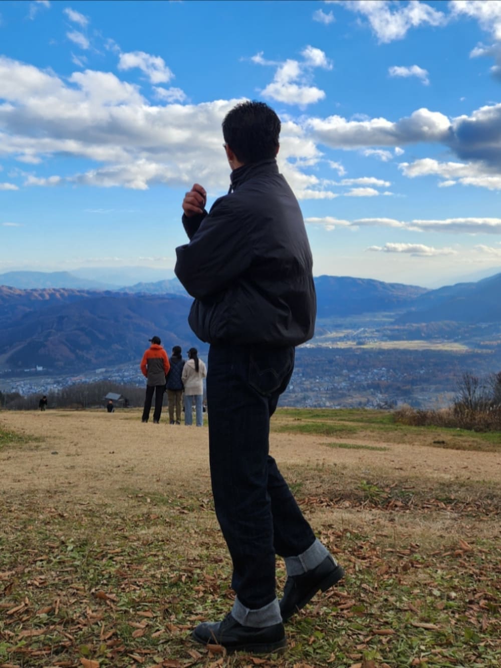 ブラック系のダウンジャケット/コート、ブルー系のデニムパンツ、ブラック系のブーツを着用したメンズの秋コーディネートの4枚目の写真