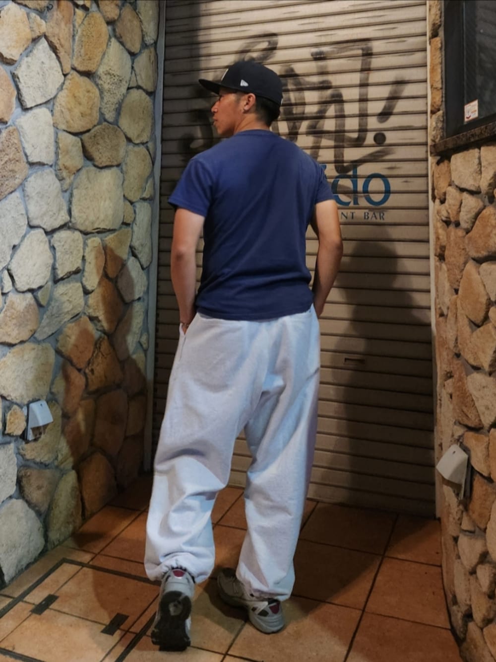 ブルー系のTシャツ/カットソー、グレー系のスウェットパンツ、グレー系のスニーカーを着用したメンズの春コーディネートの3枚目の写真