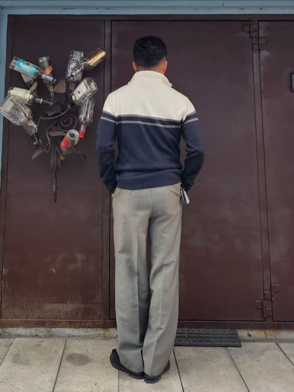 ブラック系のニット/セーター、グレー系のスラックス、ブラック系のローファーを着用したメンズの冬コーディネートの3枚目の写真