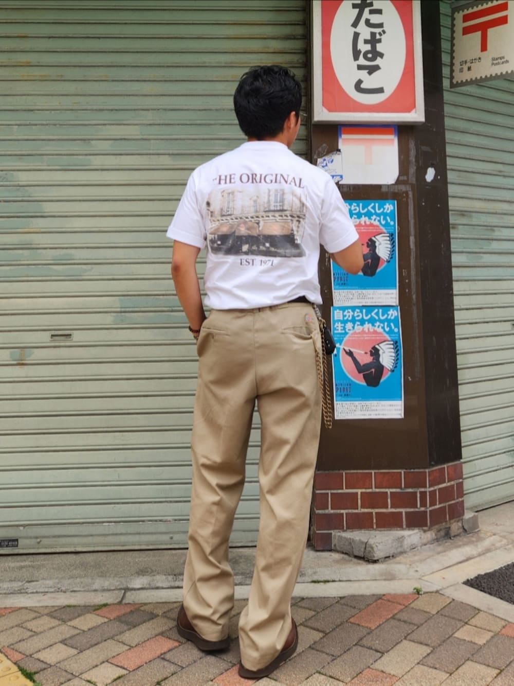 ホワイト系のTシャツ/カットソー、ベージュ系のチノパンツ、ブラウン系のブーツを着用したメンズの春コーディネートの3枚目の写真