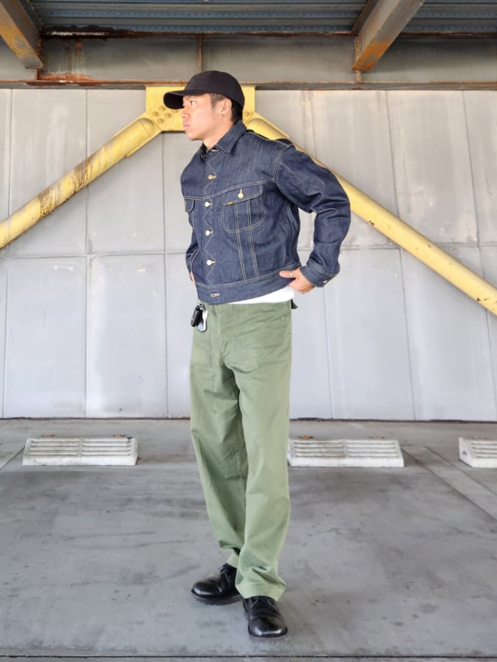 ブルー系のデニムジャケット、グリーン系のカーゴパンツ、ブラック系のブーツを着用したメンズの秋コーディネートの3枚目の写真