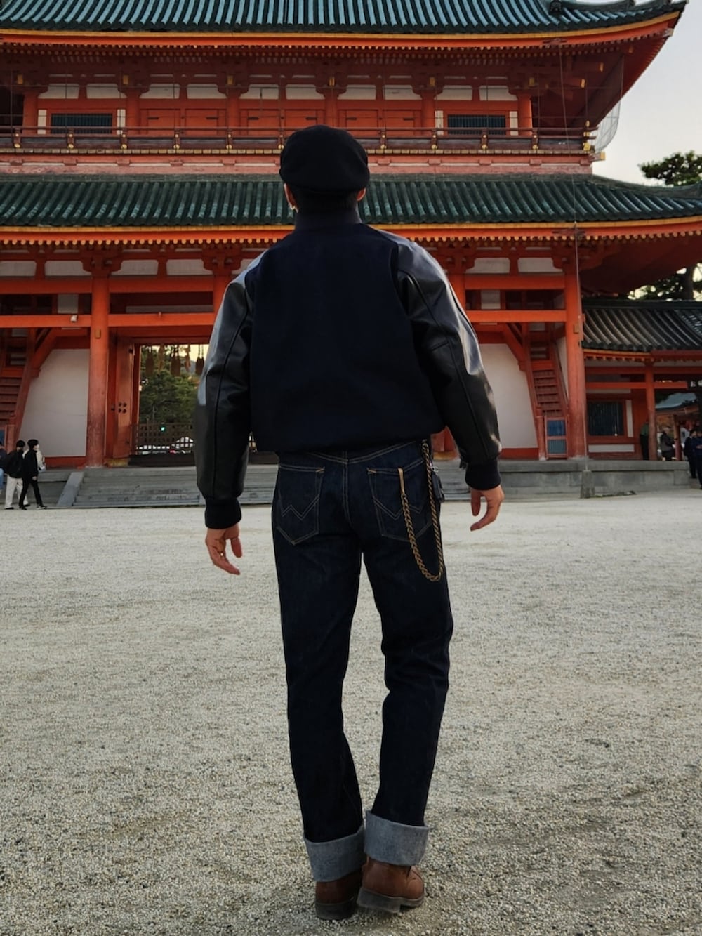 ブラック系のスタジャン、ブルー系のデニムパンツ、ブラウン系のブーツを着用したメンズの秋コーディネートの4枚目の写真