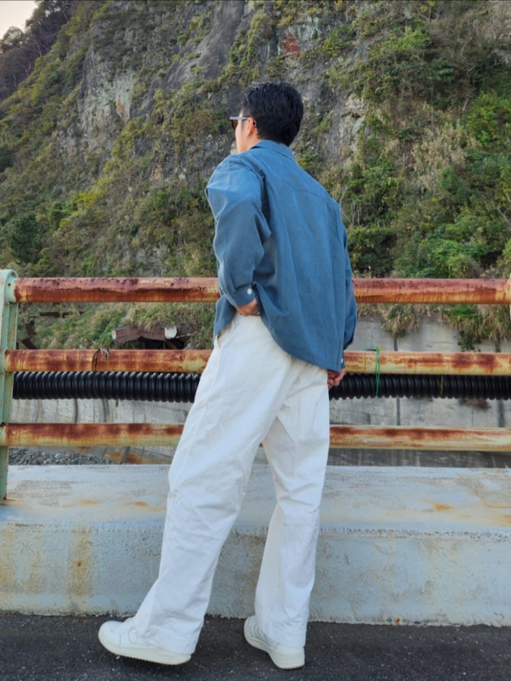 グリーン系のシャツ/ブラウス、ホワイト系のパンツ、ホワイト系のスニーカーを着用したメンズの秋コーディネートの4枚目の写真