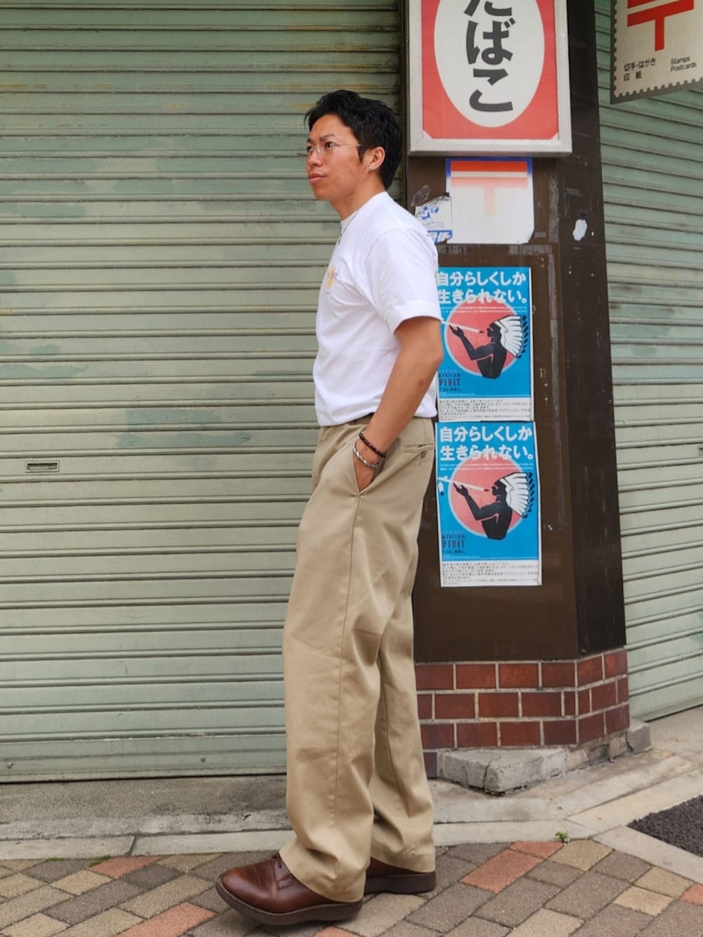 ホワイト系のTシャツ/カットソー、ベージュ系のチノパンツ、ブラウン系のブーツを着用したメンズの春コーディネートの2枚目の写真