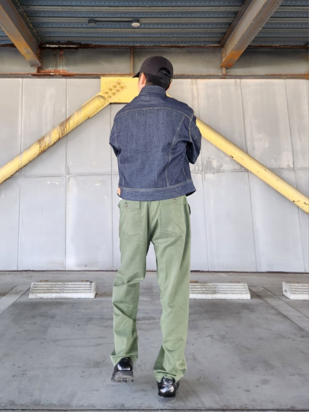 ブルー系のデニムジャケット、グリーン系のカーゴパンツ、ブラック系のブーツを着用したメンズの秋コーディネートの5枚目の写真