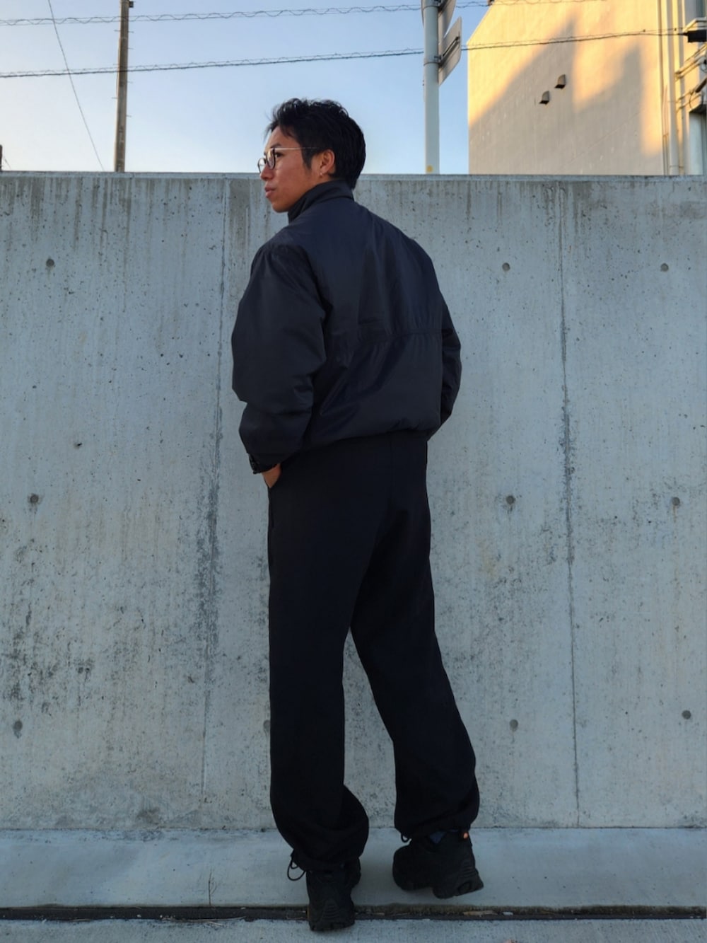 ブラック系のダウンジャケット/コート、ブラック系のスラックス、ブラック系のスニーカーを着用したメンズの冬コーディネートの4枚目の写真