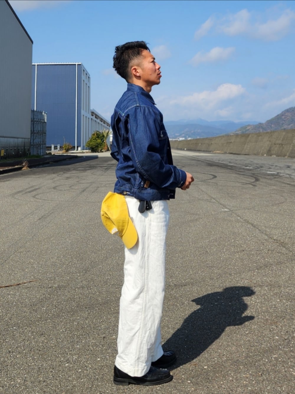 ホワイト系のパンツ、ブラック系のローファー、ブルー系のデニムジャケットを着用したメンズの冬コーディネートの3枚目の写真