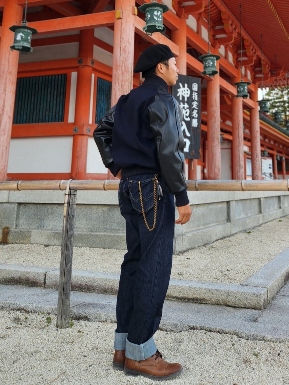 ブラック系のスタジャン、ブルー系のデニムパンツ、ブラウン系のブーツを着用したメンズの秋コーディネートの2枚目の写真