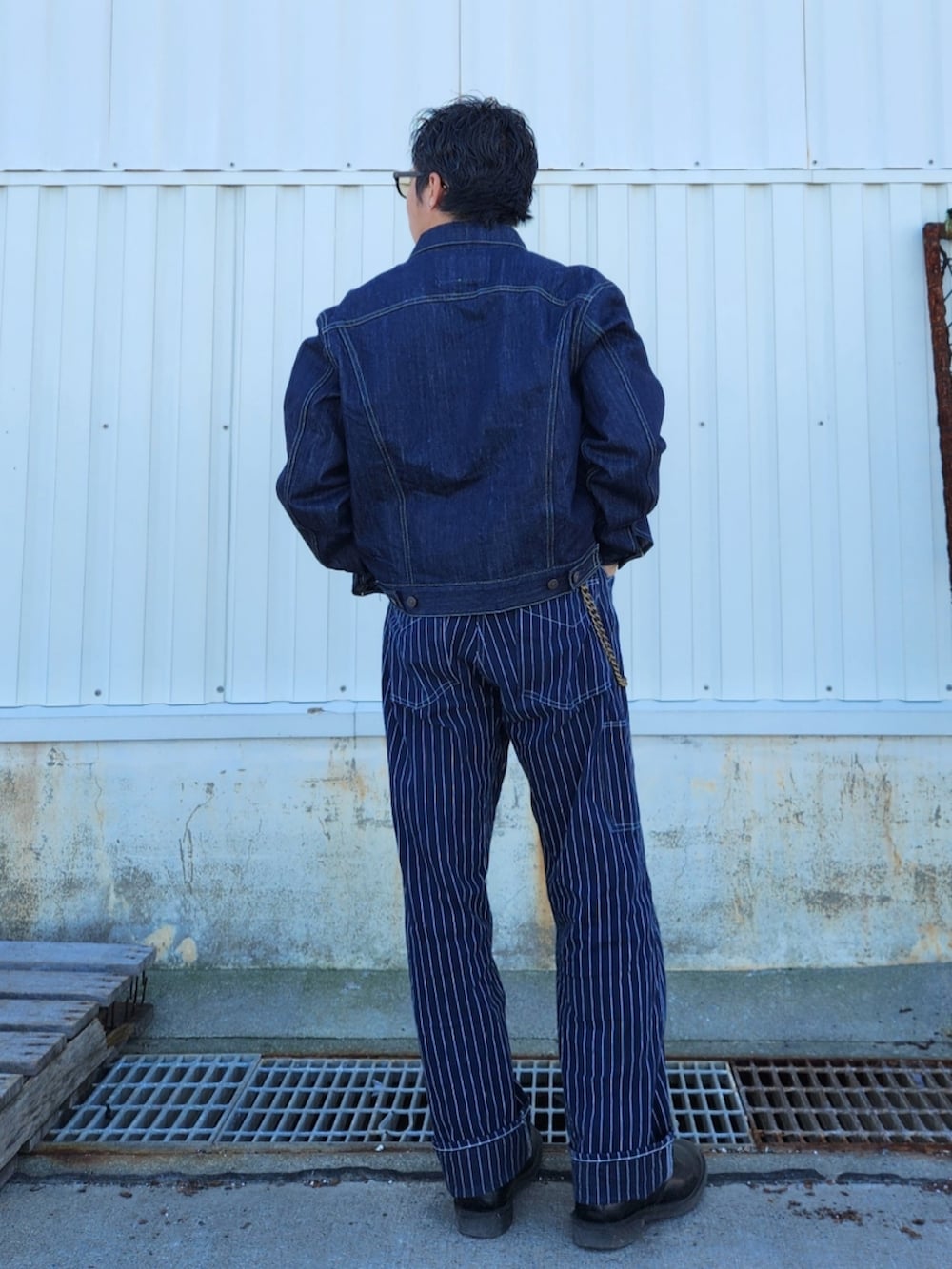 ブルー系のパンツ、グレー系のスウェット、ブルー系のデニムジャケットを着用したメンズの冬コーディネートの4枚目の写真