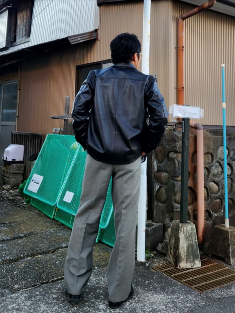 ベージュ系のシャツ/ブラウス、ブラック系のライダースジャケット、グレー系のスラックスを着用したメンズの冬コーディネートの3枚目の写真