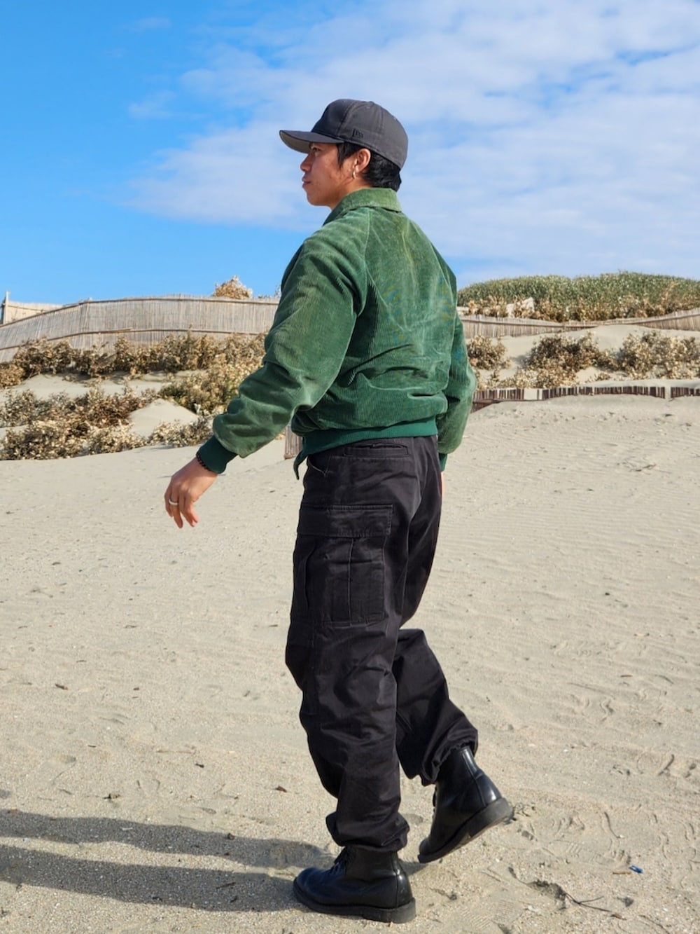 ブラック系のカーゴパンツ、ブラック系のブーツ、グリーン系のジャケット/アウターを着用したメンズの冬コーディネートの2枚目の写真