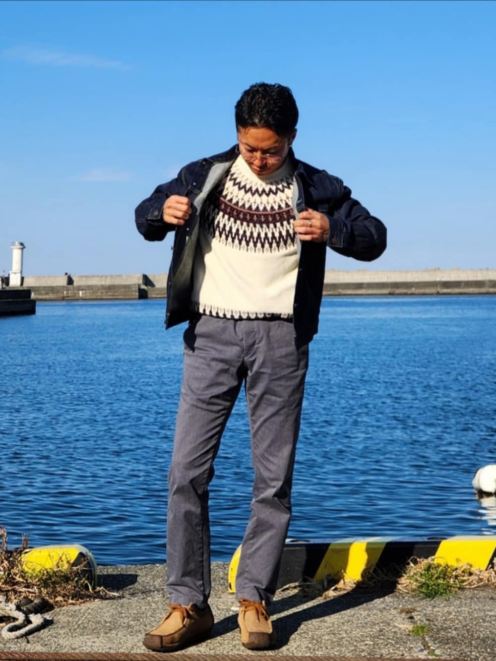 ホワイト系のニット/セーター、ブルー系のデニムジャケット、グレー系のチノパンツを着用したメンズの春コーディネートの2枚目の写真