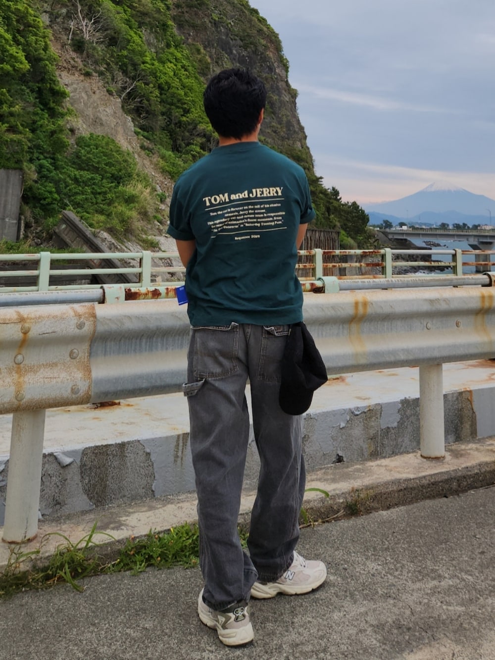 グリーン系のTシャツ/カットソー、ホワイト系のスニーカー、グレー系のデニムパンツを着用したメンズの春コーディネートの4枚目の写真