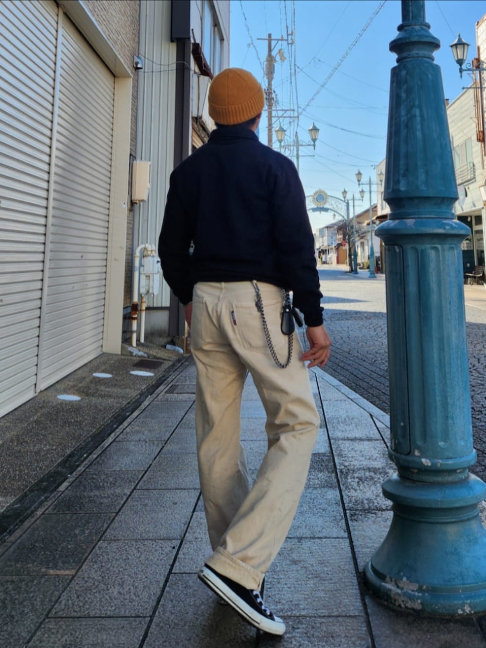 ホワイト系のデニムパンツ、ブラック系のスニーカー、ブラック系のスウェットを着用したメンズの冬コーディネートの2枚目の写真