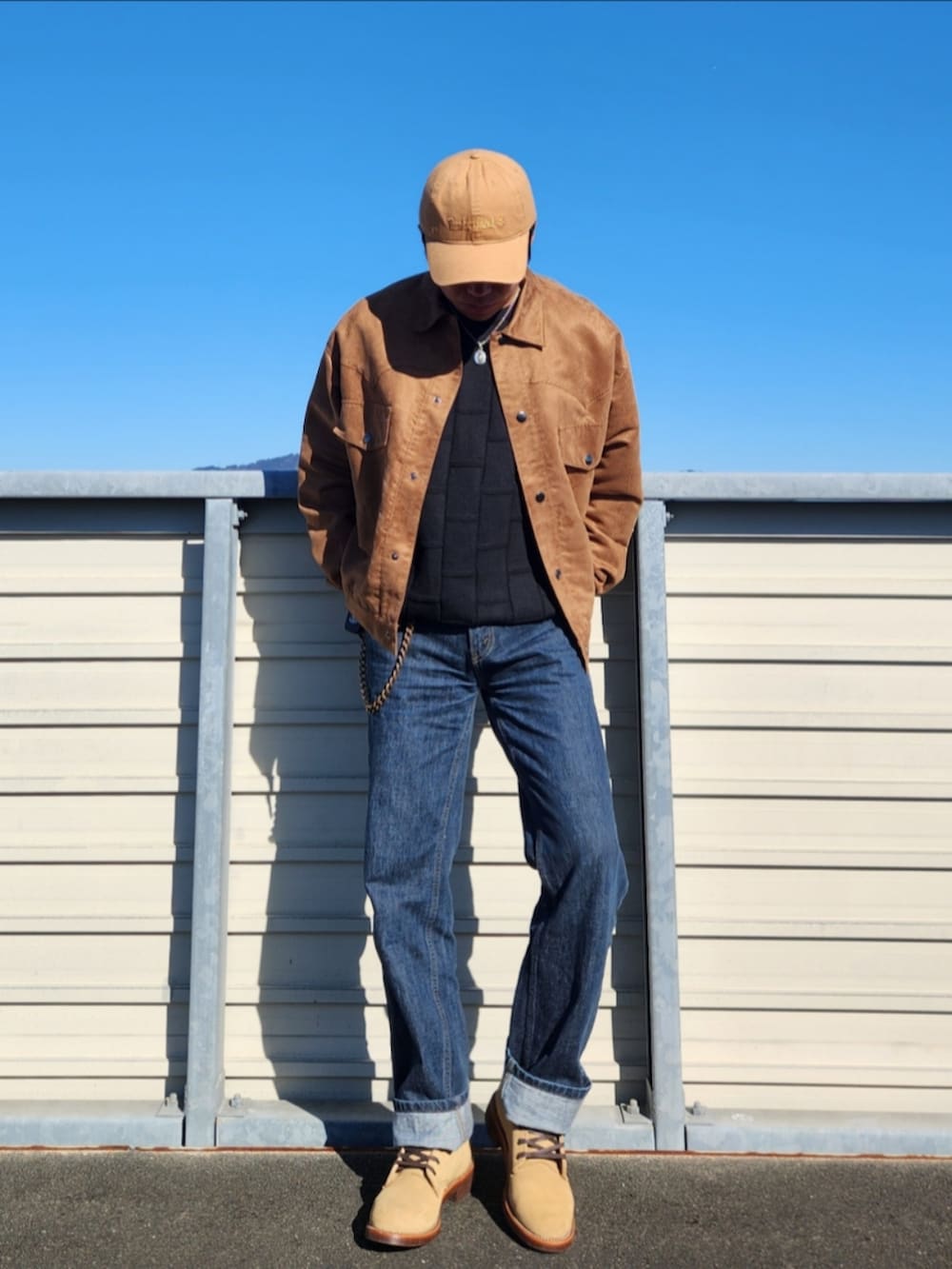 ブラック系のニット/セーター、ブラウン系のブルゾン、ブルー系のデニムパンツを着用したメンズの冬コーディネートの2枚目の写真