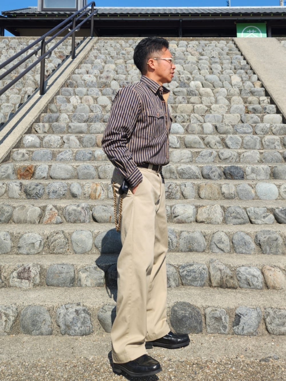 ベージュ系のチノパンツ、ブラック系のローファー、ブルー系のシャツ/ブラウスを着用したメンズの春コーディネートの2枚目の写真