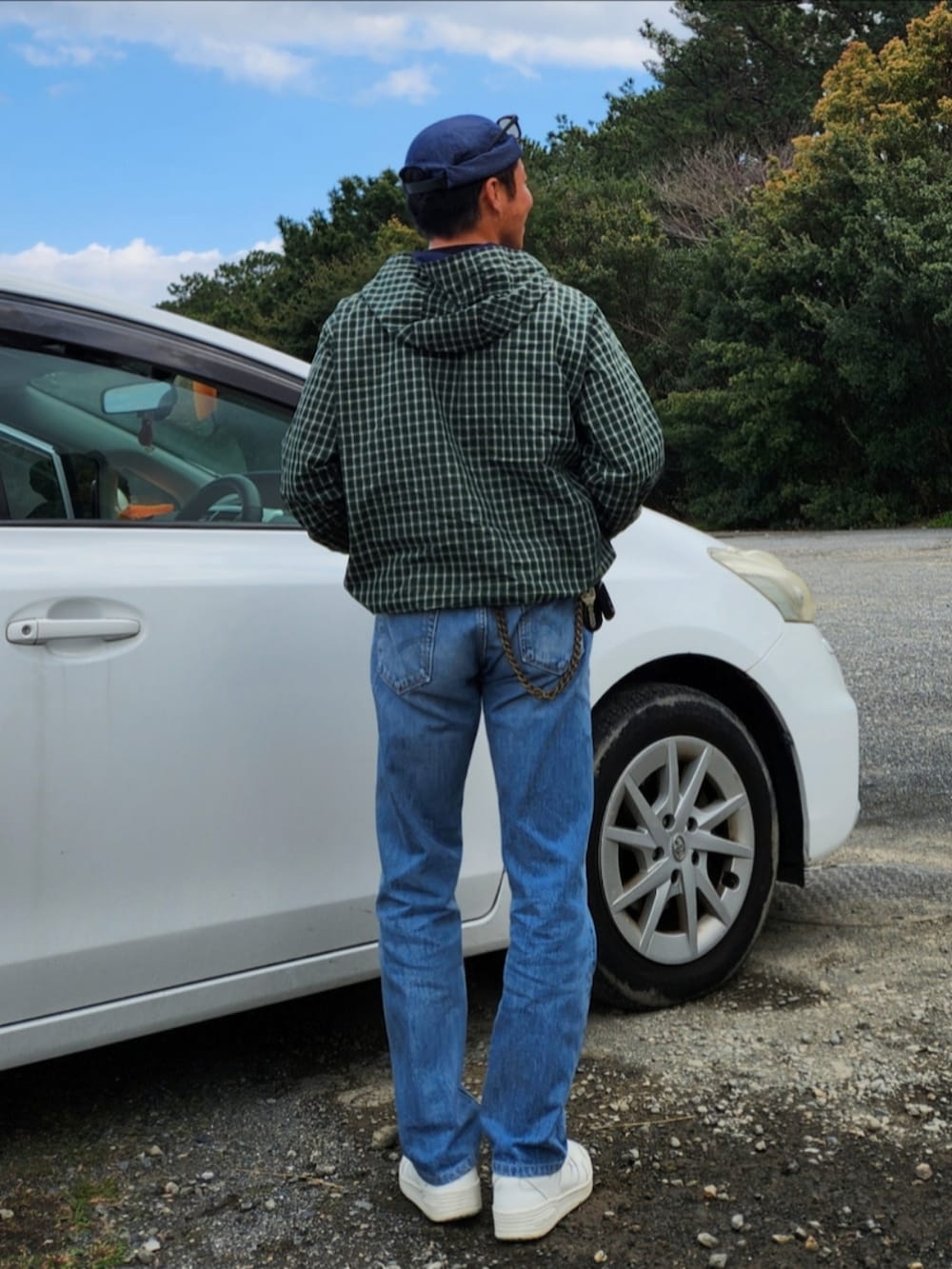 グリーン系のシャツ/ブラウス、ブルー系のデニムパンツ、ホワイト系のスニーカーを着用したメンズの春コーディネートの3枚目の写真