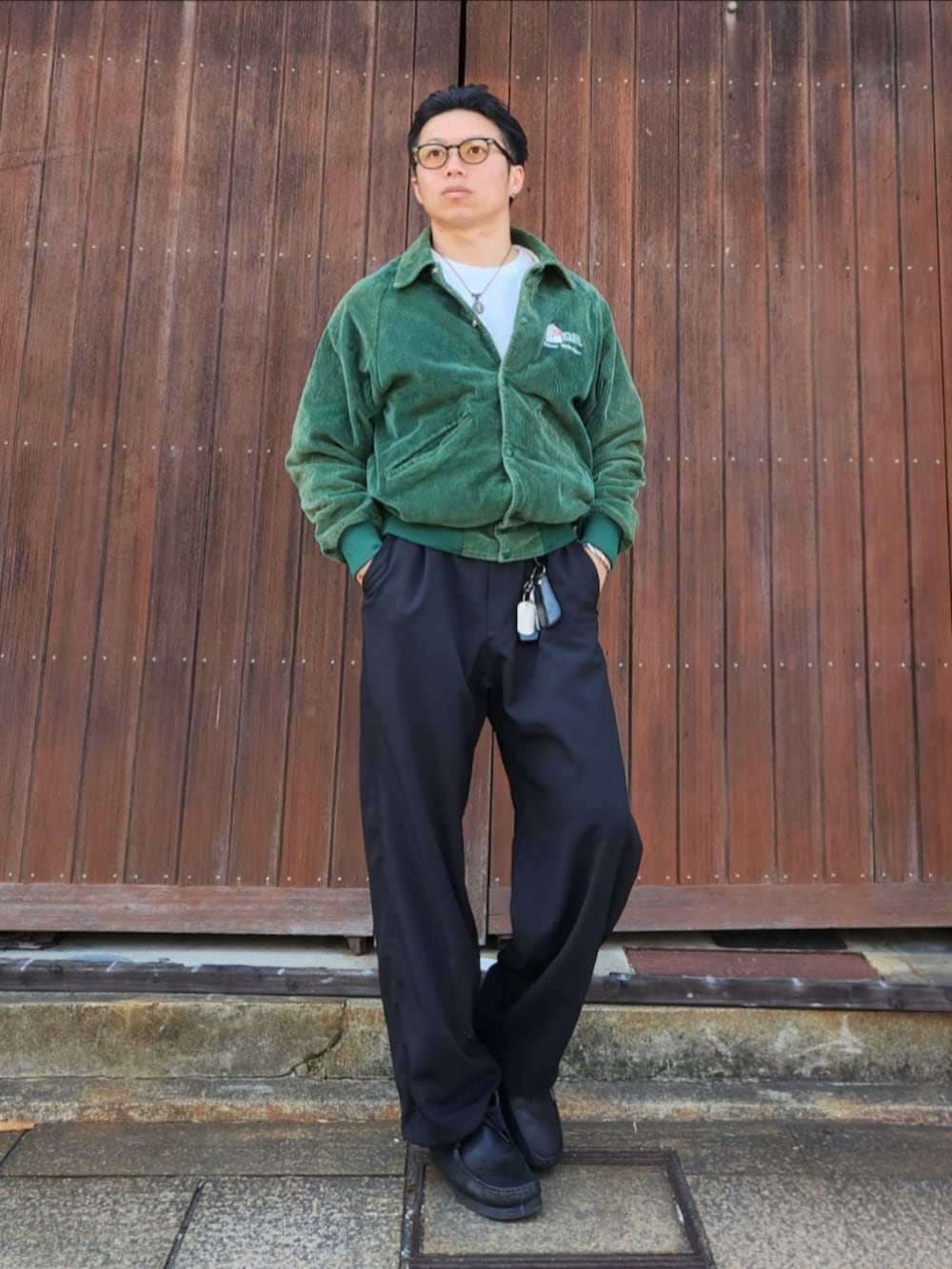 ブラック系のスラックス、ブラック系のローファー、グリーン系のジャケット/アウターを着用したメンズの春コーディネートの2枚目の写真