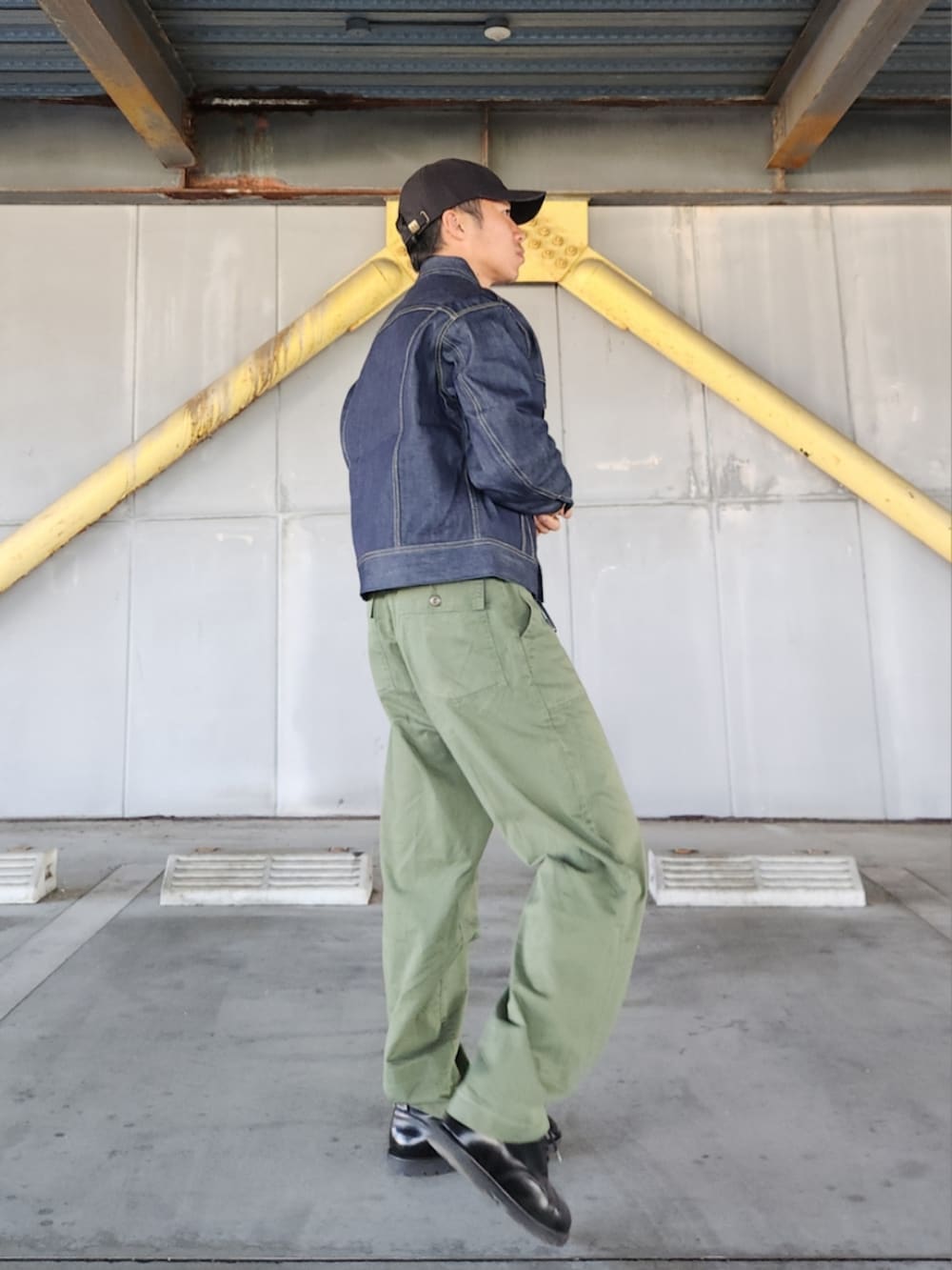 ブルー系のデニムジャケット、グリーン系のカーゴパンツ、ブラック系のブーツを着用したメンズの秋コーディネートの4枚目の写真