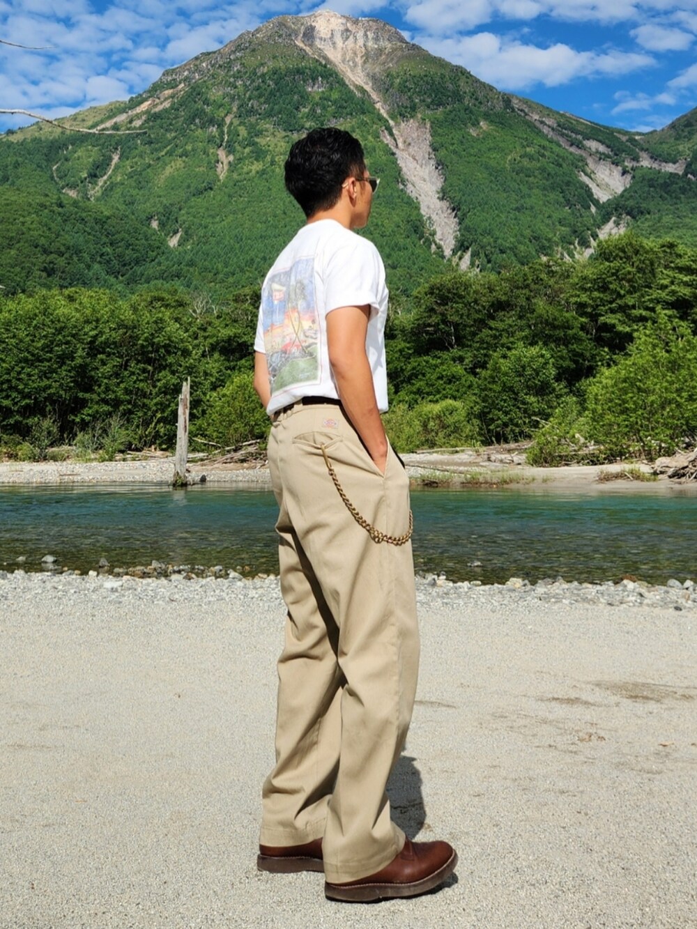 ベージュ系のチノパンツ、ブラウン系のブーツ、ホワイト系のTシャツ/カットソーを着用したメンズの夏コーディネートの2枚目の写真