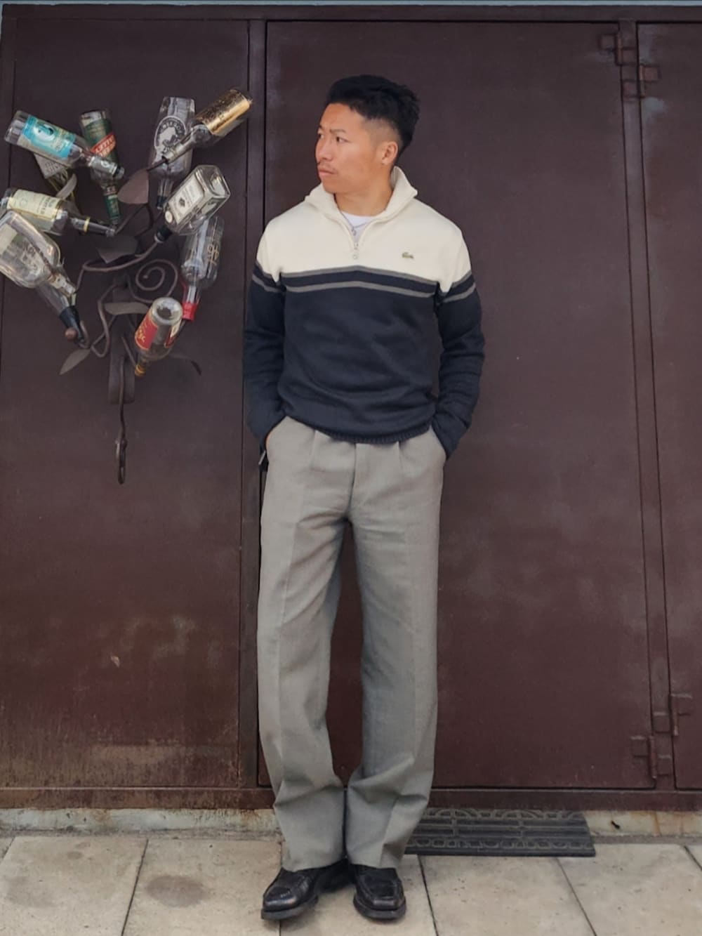 ブラック系のニット/セーター、グレー系のスラックス、ブラック系のローファーを着用したメンズの冬コーディネートの2枚目の写真