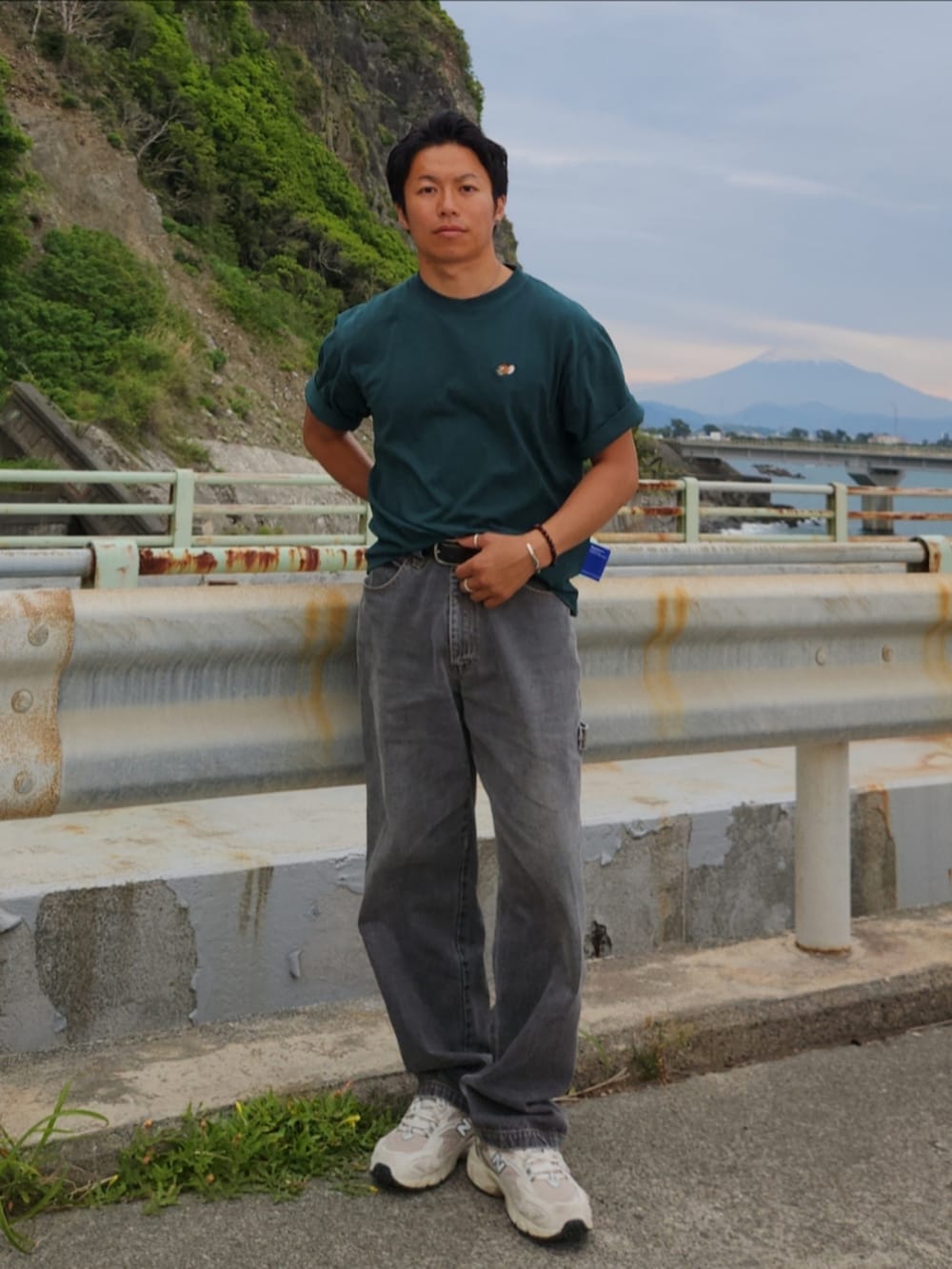 グリーン系のTシャツ/カットソー、ホワイト系のスニーカー、グレー系のデニムパンツを着用したメンズの春コーディネートの2枚目の写真