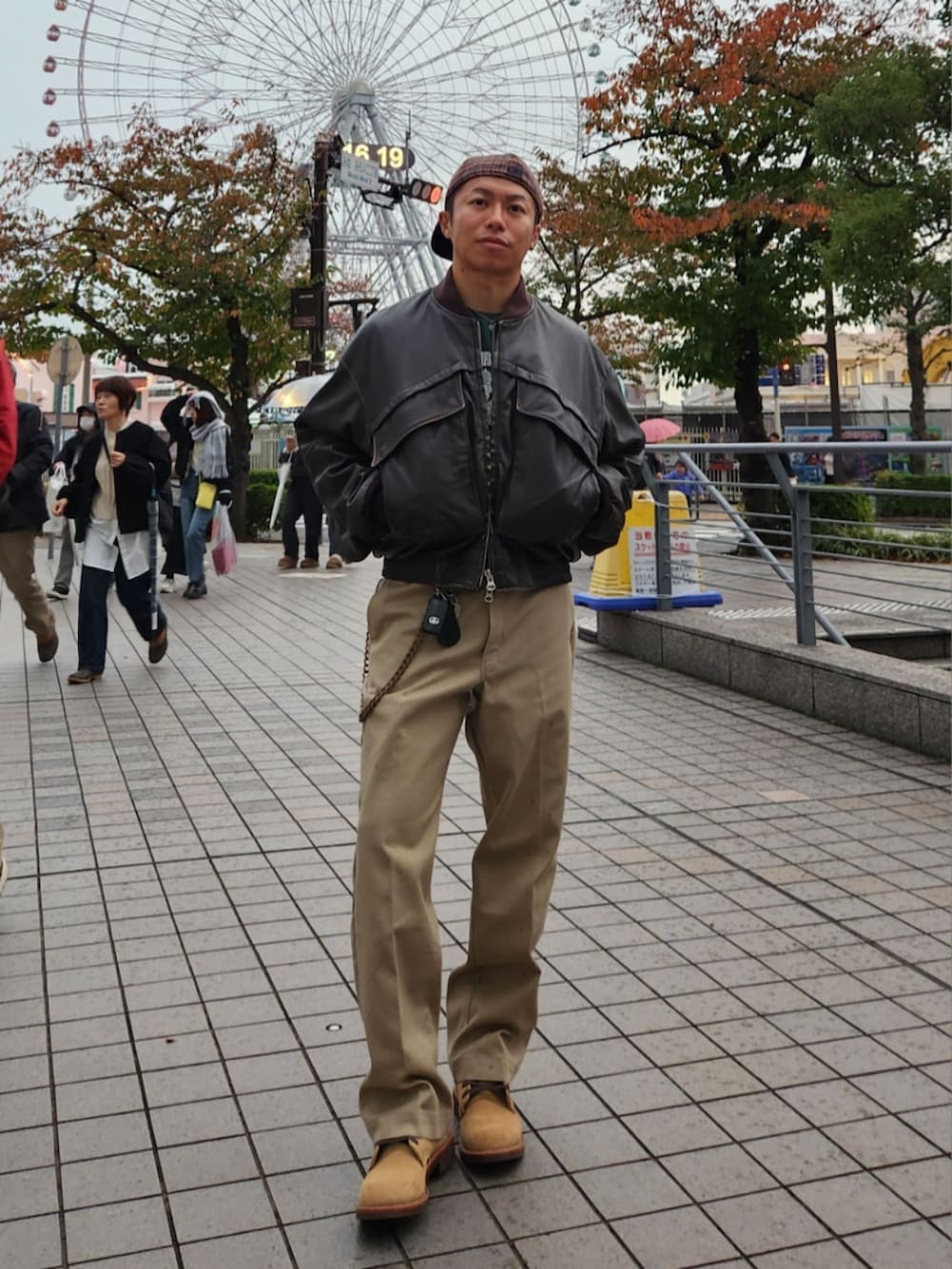 ブラウン系のブルゾン、グリーン系のスウェット、ベージュ系のチノパンツを着用したメンズの秋コーディネートの2枚目の写真