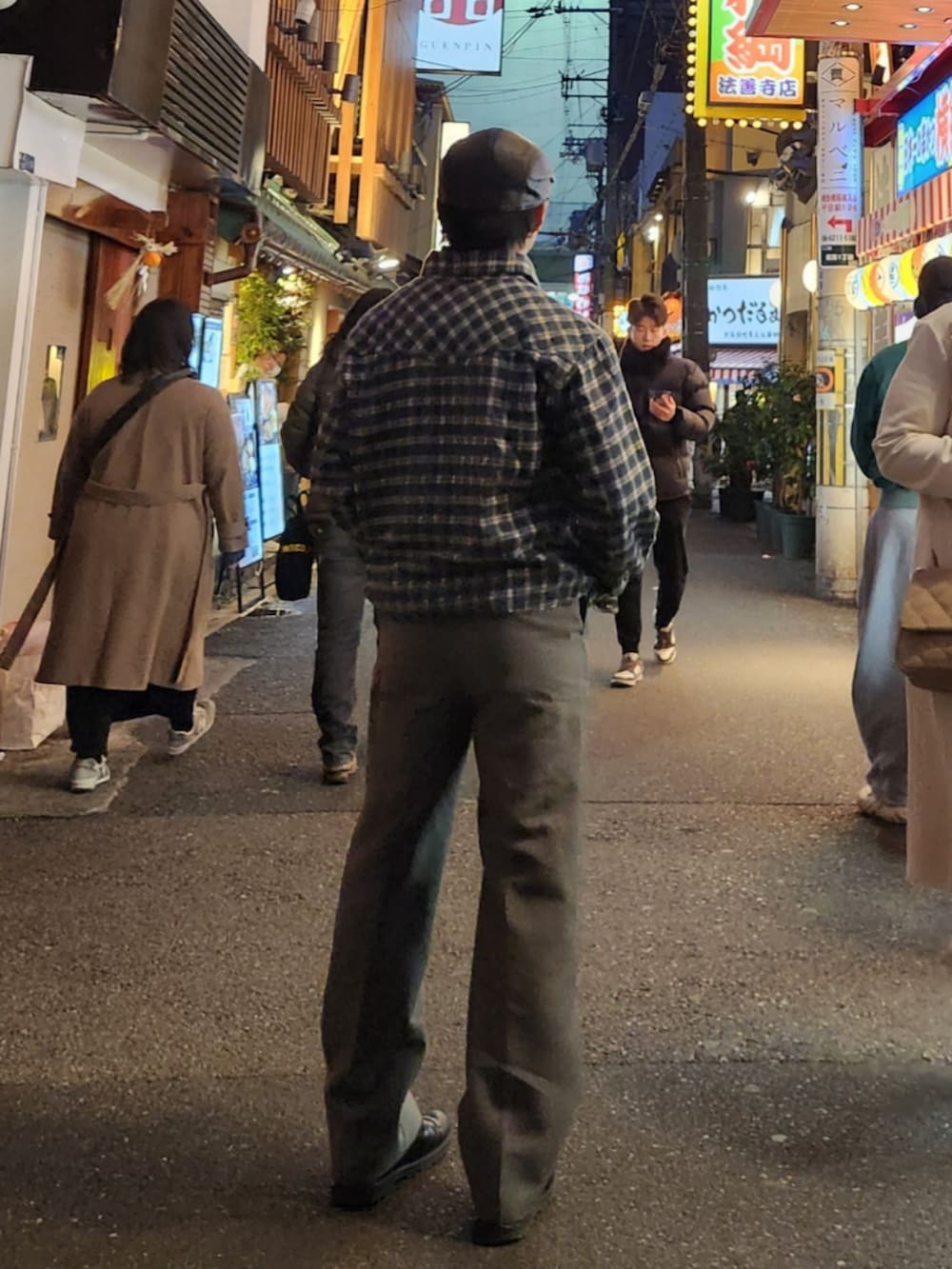 グレー系のスラックス、ブラック系のブーツ、ブラック系のその他トップスを着用したメンズの冬コーディネートの2枚目の写真