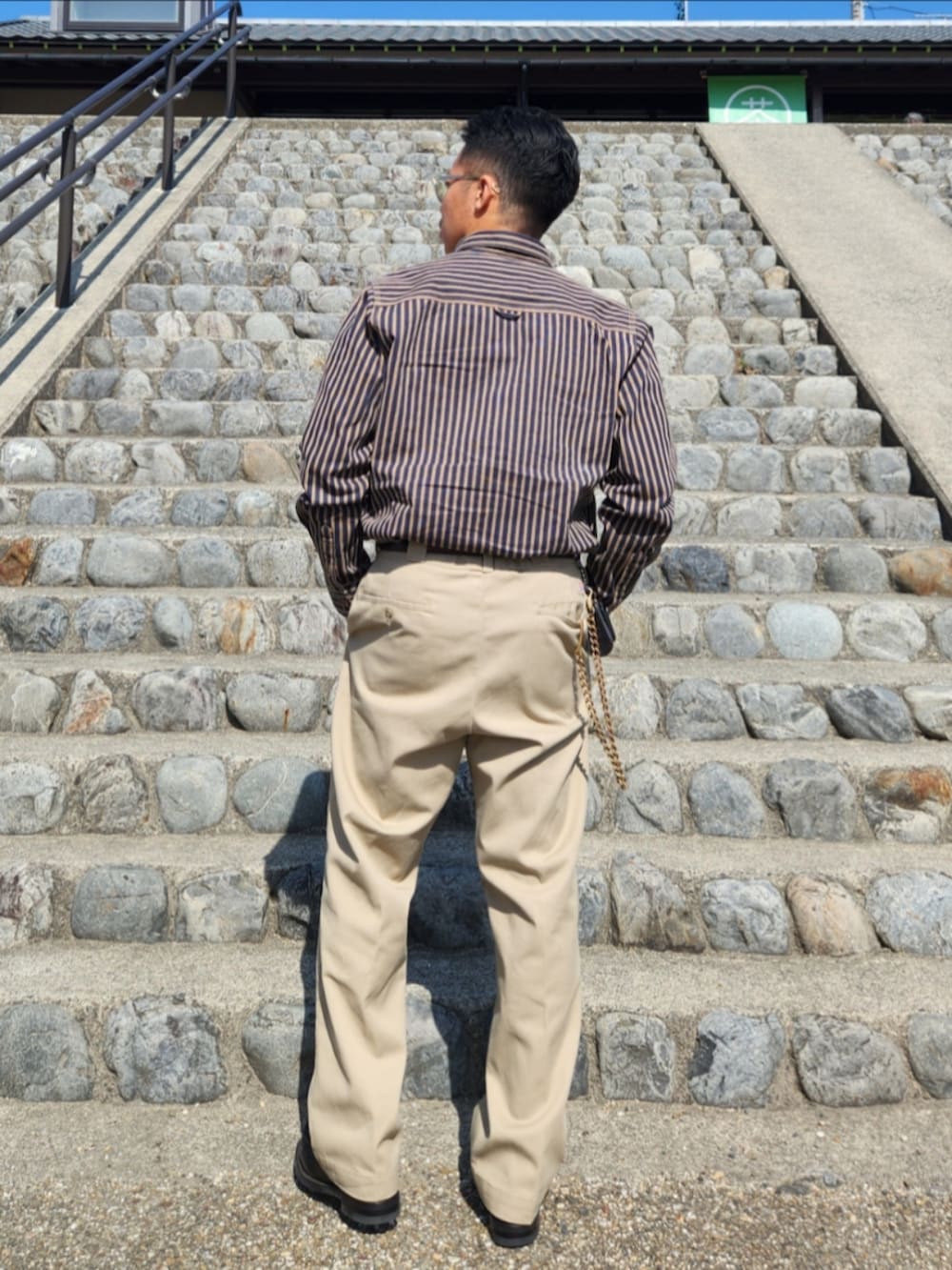 ベージュ系のチノパンツ、ブラック系のローファー、ブルー系のシャツ/ブラウスを着用したメンズの春コーディネートの3枚目の写真