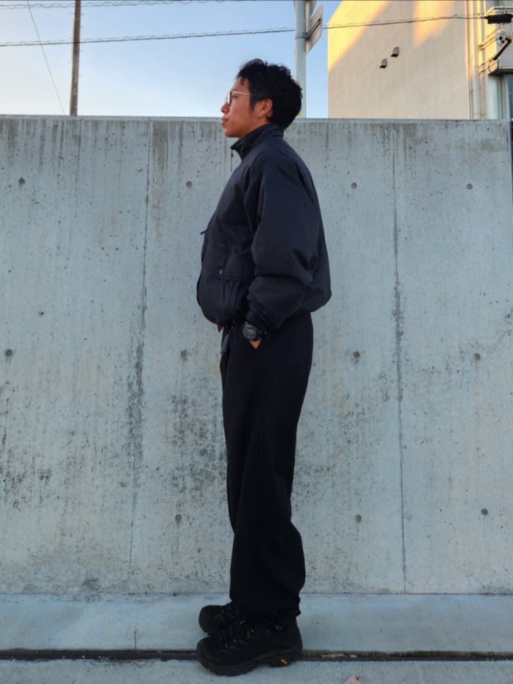 ブラック系のダウンジャケット/コート、ブラック系のスラックス、ブラック系のスニーカーを着用したメンズの冬コーディネートの3枚目の写真